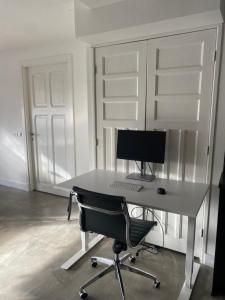Cette chambre comprend un bureau avec un ordinateur et une chaise. dans l'établissement Stijlvol ruim studio-appartement nabij historisch centrum, à Amersfoort