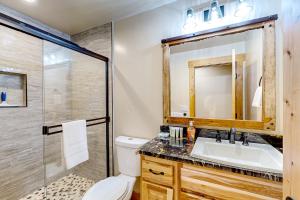 een badkamer met een toilet, een wastafel en een douche bij The Clicky-Clicky Cabin in Tahoma