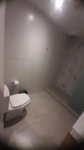 a white bathroom with a toilet in a room at Macondo in Asunción