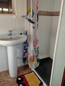 a bathroom with a sink and a shower curtain at Villa 365 in La Rábita