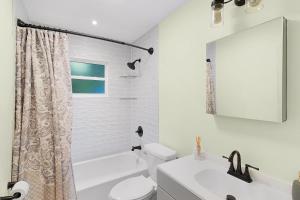 a white bathroom with a toilet and a sink at A Ray of Turquoise in Belleview +21 photos