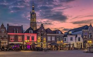 a group of buildings with a clock tower at sunset at Stijlvol ruim studio-appartement nabij historisch centrum in Amersfoort