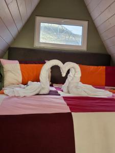 ein Bett mit zwei Schwänen aus Handtüchern in der Unterkunft La Căsuțe Luxury in Piatra Neamţ