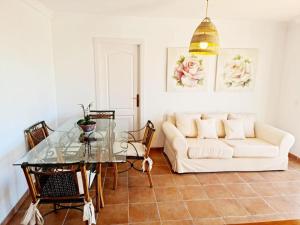 een woonkamer met een witte bank en een glazen tafel bij Blue jasmine in Cala del Moral