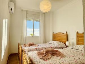 een slaapkamer met 2 bedden en handdoeken bij Blue jasmine in Cala del Moral
