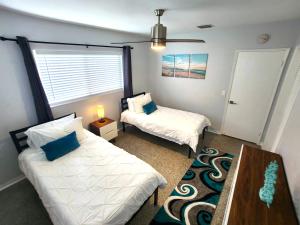 una camera da letto con due letti, un tavolo e una finestra di Paradise Awaits! Beach, King Bed, Private Yard & Workspace a Deerfield Beach