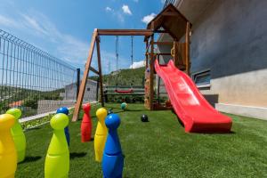 a childrens playground with a slide and a swing at Family & Child friendly Villa Violet with Salt water pool in Makarska