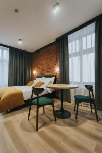 a bedroom with a bed and a table and chairs at Apartamenty BIBLIO in Łódź