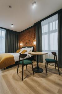 a bedroom with a bed and a table and chairs at BIBLIO Apartamenty in Łódź