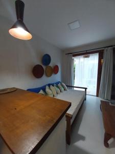 a bedroom with a bed and a table and a window at Casa Paula in Barra Grande