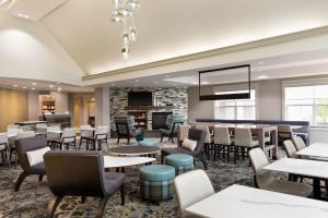 a restaurant with tables and chairs and a bar at Residence Inn by Marriott Madison West/Middleton in Middleton