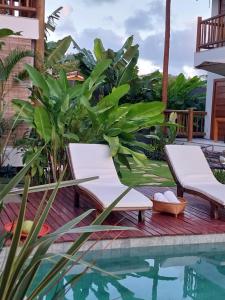 una piscina con 2 tumbonas junto a una casa en Casa Paula, en Barra Grande
