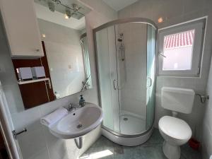 een badkamer met douche, wastafel en toilet bij Šimuni holiday home by Pag tours in Šimuni +15 foto's
