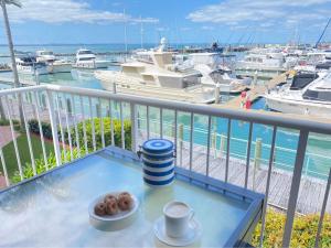 una mesa con una taza de café y donuts en el balcón en MarinaView Unit 24 - Break Free Resort- 2 Bedroom Self Contained, en Urangan