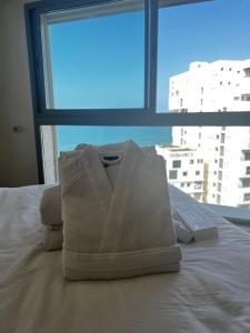 una bolsa blanca sentada en la parte superior de una cama con ventana en Magnifique appartement pleine vue mer Marina Casablanca, en Casablanca