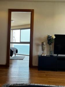 Sala de estar con TV y vistas al océano en Magnifique appartement pleine vue mer Marina Casablanca, en Casablanca
