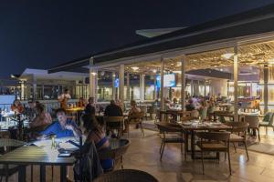 people sitting at tables in a restaurant at night at Cozy 1Br Apt - Pool - GYM in Bucerías