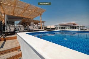 a swimming pool with chairs and a house at Cozy 1Br Apt - Pool - GYM in Bucerías