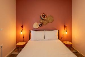 1 dormitorio con 1 cama con 2 lámparas y platos en la pared en Εξοχικό σπίτι στο Ρίο en Rio