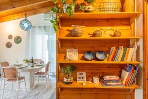 Habitación con una estantería de madera con libros y una mesa. en Εξοχικό σπίτι στο Ρίο en Rio