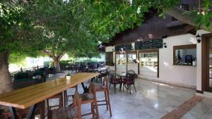 a restaurant with a long wooden table and chairs at Dobedan World Palace Hotel ''Ex Brand Alva Donna World Palace '' in Kemer