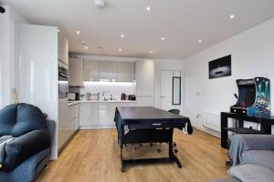 sala de estar con mesa de ping pong y cocina en Greenwich O2 Apartment, en Londres