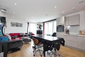 cocina y sala de estar con mesa y sillas en Greenwich O2 Apartment, en Londres