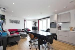 a kitchen and living room with a table and chairs at Greenwich O2 Apartment in London