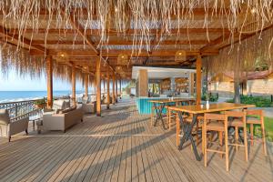 a restaurant on the beach with tables and chairs at Dobedan World Palace Hotel ''Ex Brand Alva Donna World Palace '' in Kemer