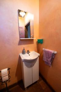 ein Badezimmer mit einem weißen Waschbecken und einem Spiegel in der Unterkunft Kuća sreće Veronika in Nova Gradiška