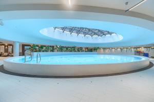 einen großen Whirlpool in einem Einkaufszentrum mit blauen Lichtern in der Unterkunft Comfy Apartments 4-5th Floor Hanza Tower - Sauna & Pool in Stettin