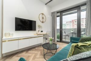 ein Wohnzimmer mit einem Sofa und einem TV in der Unterkunft Comfy Apartments 4-5th Floor Hanza Tower - Sauna & Pool in Stettin