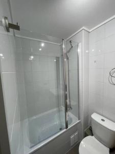 a white bathroom with a shower and a toilet at Nuevo, céntrico y acogedor dpto in Concepción