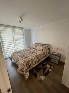 1 dormitorio con 1 cama y mesita de noche con lámpara en Nuevo, céntrico y acogedor dpto, en Concepción