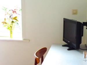 - un bureau avec une télévision sur une table et une chaise dans l'établissement B&B La Chambre du Zodiaque, à Bruxelles
