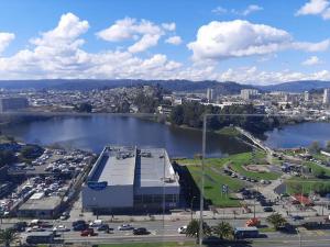 un gran edificio junto a una gran masa de agua en Nuevo, céntrico y acogedor dpto, en Concepción