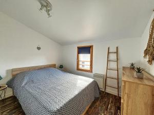 1 dormitorio con cama, escalera y ventana en Les Rêves du Crotoy, en Le Crotoy