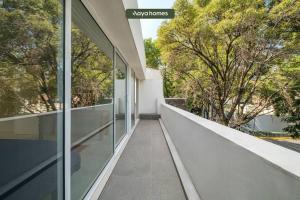 un balcón vacío de una casa con árboles en New 2BR Condo Perfect for Long Stays w/ Balcony, en Ciudad de México
