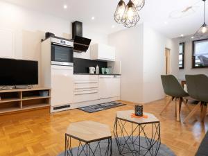 LangenthalにあるFerienapartment Am Gaulsbachのテレビ付きの大きな白いキッチンのあるリビングルーム