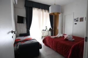 a bedroom with a red bed and a window at B&B Royal Palace of Napoli & Reggia di Caserta in Caserta