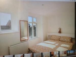 sypialnia z łóżkiem, lustrem i oknami w obiekcie Beach & Harbour View House w mieście Weymouth