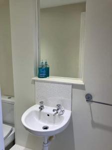 a white bathroom with a sink and a toilet at Beach & Harbour View House in Weymouth