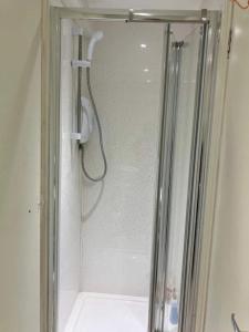 a shower with a glass door in a bathroom at Beach & Harbour View House in Weymouth
