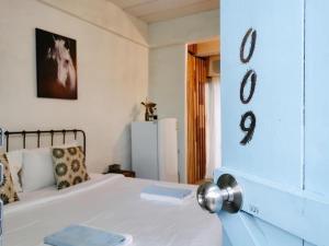ein Schlafzimmer mit einem weißen Bett und Zahlen an der Wand in der Unterkunft De Lit in Ubon Ratchathani