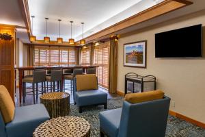 a waiting room with a bar with chairs and a tv at Comfort Inn in Missoula