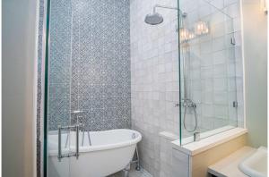 a bathroom with a tub and a glass shower at Exquisite Studio Guesthouse Near Downtowns Core in San Antonio