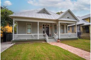 a gray house with a porch with a porch at Exquisite Studio Guesthouse Near Downtowns Core in San Antonio