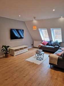 ein Wohnzimmer mit einem Sofa und einem Flachbild-TV in der Unterkunft Ferienbauernhof Ennenhof in Schneverdingen