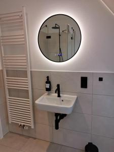 a bathroom with a white sink and a mirror at Ferienbauernhof Ennenhof in Schneverdingen