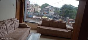 sala de estar con sofá y ventana grande en Rk Hotal en Pusad